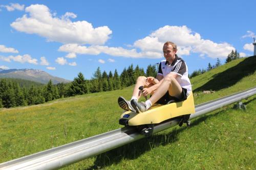 a man riding on a toy train in a field at Ansitz Hofer in Fulpmes