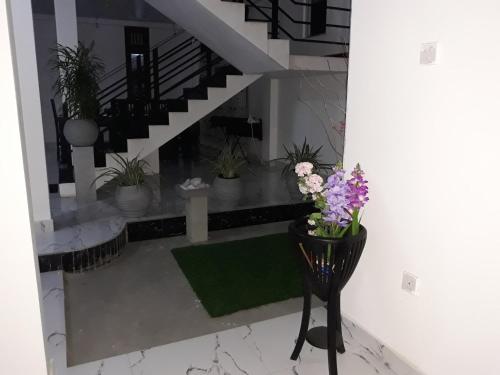 a lobby with potted plants and a stair case at Rohan's Residence in Kandana