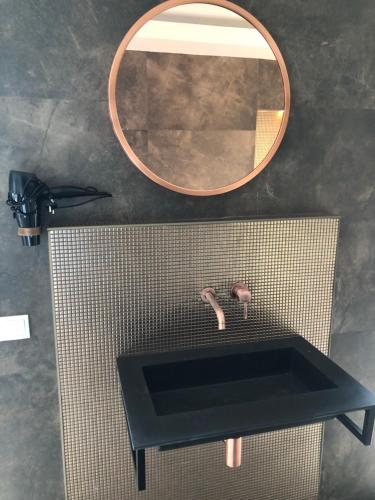 a bathroom with a black sink and a mirror at Luxexcellent super suite in Nuland