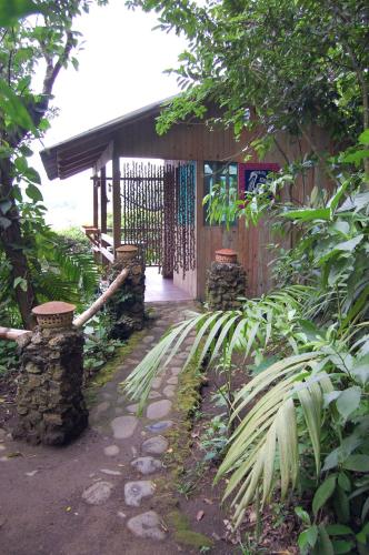 a wooden building with a gate in a garden at Reserva Ecologica Nanciyaga in Catemaco