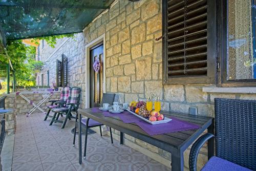 a table with a bowl of fruit on a patio at Apartments Neppa in Postira