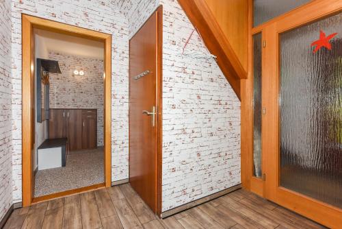 a hallway with a door and a brick wall at Haus am Kajedeich mit Frühstücksoption in Bensersiel