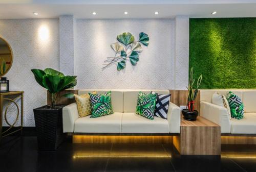 a living room with a white couch with colorful pillows at My Hotel @ KL Sentral in Kuala Lumpur