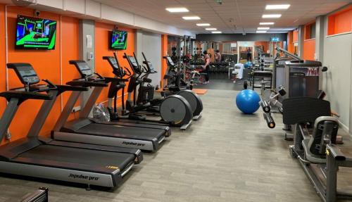 a gym with a row of treadmills and machines at Swanage Bay View caravan in Swanage