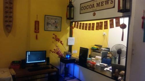 a room with a desk with a computer on it at Cocoa Mews Cafe and Homestay in George Town