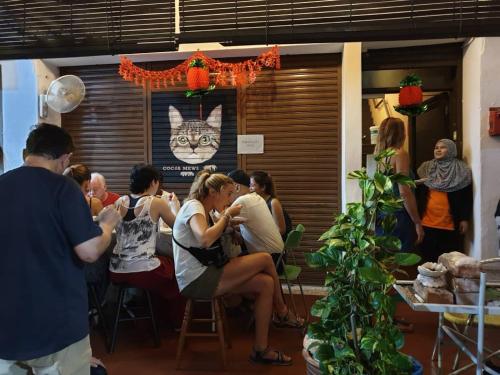 a group of people sitting at tables in a room at Cocoa Mews Cafe and Homestay in George Town