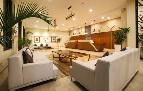 a lobby with white couches and a table at juSTa Rangers Munnar in Munnar