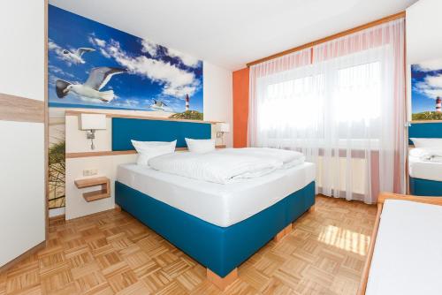 a bedroom with a blue and white bed and a window at Haus am Kajedeich mit Frühstücksoption in Bensersiel