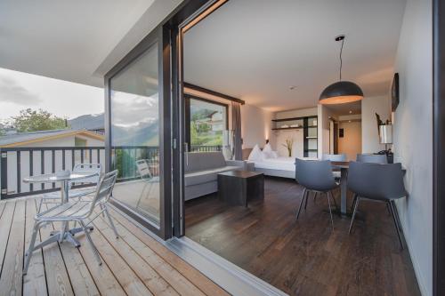 Camera dotata di balcone con tavolo e sedie. di Hotel & Appartements Oberhofer a Telfes im Stubai