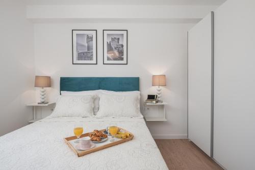 een wit bed met een dienblad met eten erop bij Luxury Suite Lady Of The Rock in Dubrovnik