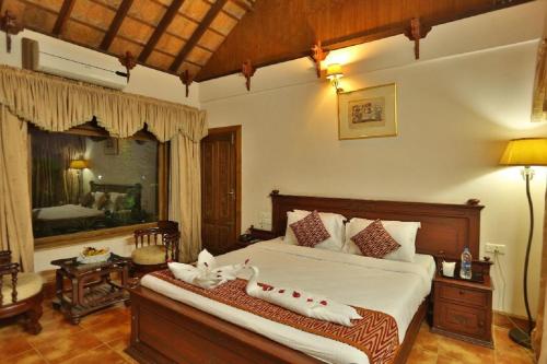 een slaapkamer met een bed en een grote spiegel bij Kalathil Lake Resort in Vaikom