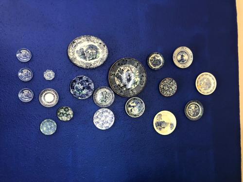 a group of old plates on a blue table at Bella Blue Guesthouse in Bloemfontein