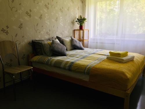 um quarto com uma cama com um cobertor amarelo e uma janela em Oja 134 Apartments em Pärnu
