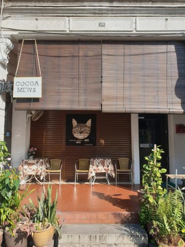 a building with a sign with a cat on the wall at Cocoa Mews Cafe and Homestay in George Town