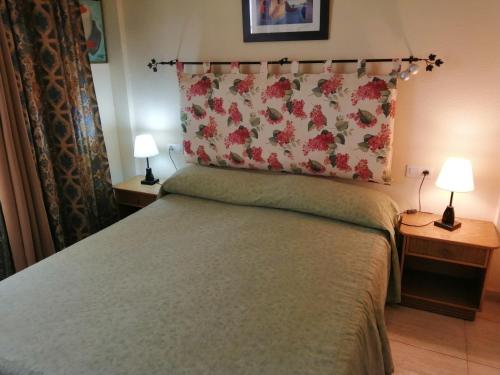 カジャオ・サルバヘにあるArcoirisのベッドルーム1室(ベッド1台、ランプ2つ、テーブル2台付)