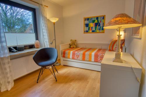 a bedroom with a bed and a desk and a lamp at Ferienhaus Schils Zur alten Heidegärtnerei in Bispingen
