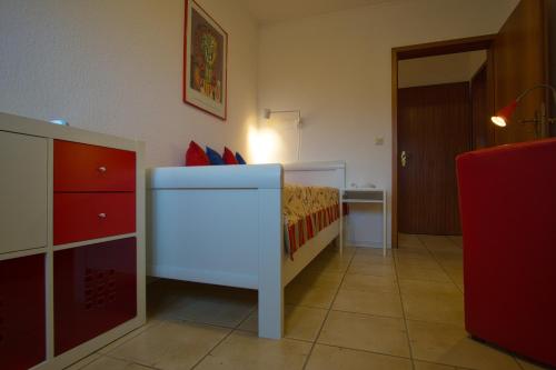 a small bedroom with a bed and a small cabinet at Ferienhaus Schils Zur alten Heidegärtnerei in Bispingen