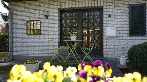 a house with yellow and purple flowers in front of it at Ferienhaus Schils Zur alten Heidegärtnerei in Bispingen