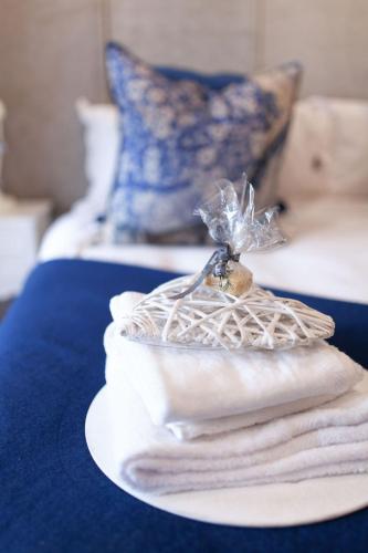 a pile of towels on a plate on a bed at Bella Blue Guesthouse in Bloemfontein