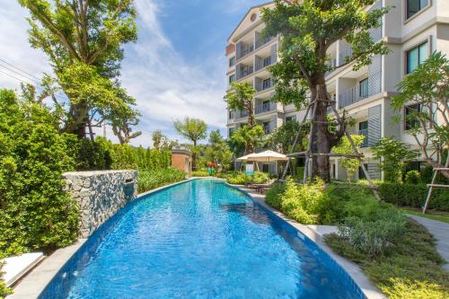 a swimming pool in front of a building at The Title Residencies Naiyang by Beringela in Nai Yang Beach