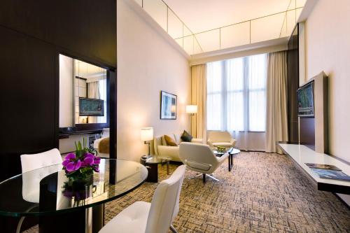 a hotel room with a table and a living room at Regal Airport Hotel in Hong Kong