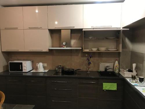 a kitchen with white cabinets and a black counter top at DAUGAVPILS in Daugavpils
