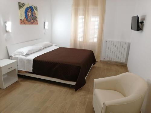 a bedroom with a bed and a chair and a couch at Opera Boutique Rooms in Monreale