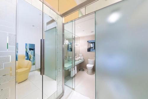 a bathroom with a toilet and a glass door at Regal Airport Hotel in Hong Kong