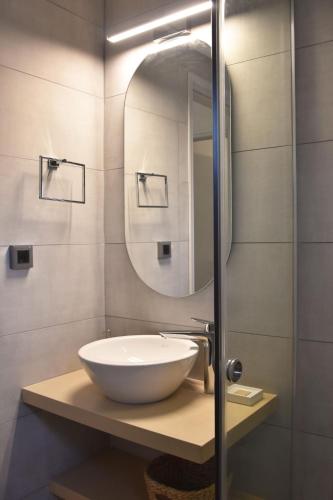 a bathroom with a bowl sink and a mirror at Olivella Villas by Vatos in Keri