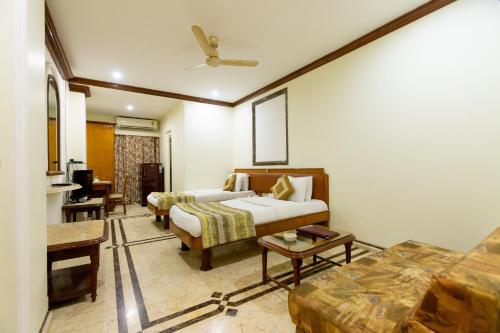 a hotel room with a bed and a couch at Garden Hotel in Mumbai