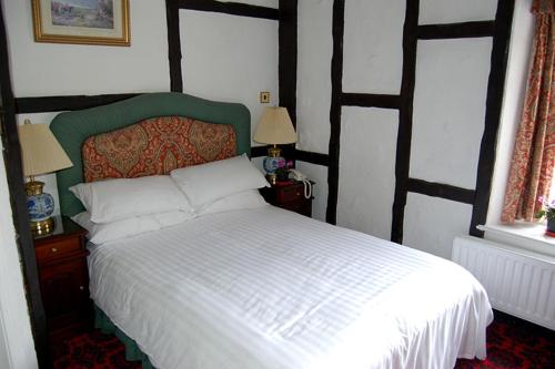 1 Schlafzimmer mit einem weißen Bett und 2 Fenstern in der Unterkunft Dun Cow Inn in Sedgefield