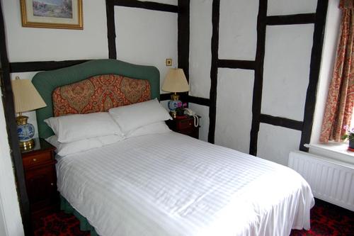 a bedroom with a white bed and two windows at Dun Cow Inn in Sedgefield
