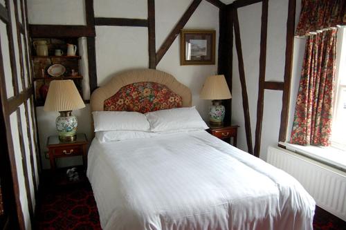 a bedroom with a white bed with two lamps on tables at Dun Cow Inn in Sedgefield