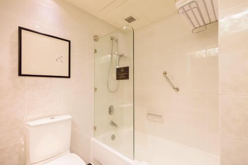 a bathroom with a shower and a toilet at Regal Airport Hotel in Hong Kong