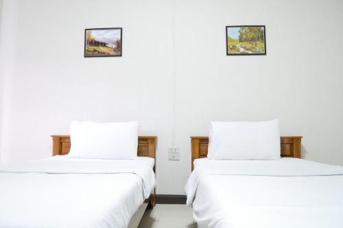 two beds in a room with white walls at Fang villa mansion in Fang