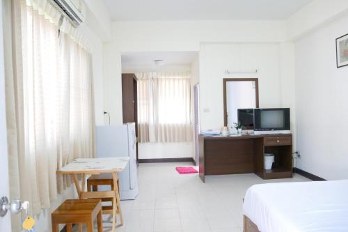 a room with a bed and a table and a refrigerator at Fang villa mansion in Fang