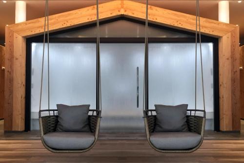 two chairs in front of a gym with a swing at Hôtel Les Bains d'Ovronnaz in Ovronnaz