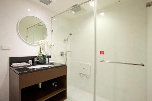 bagno con doccia, lavandino e specchio di Tai Hope Hotel a Taipei