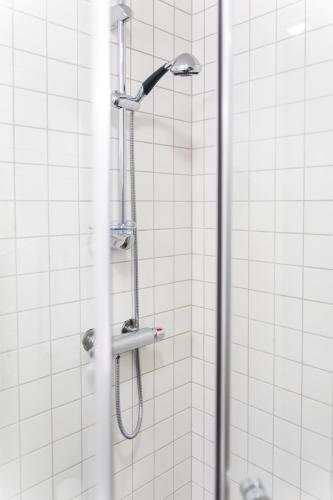 a shower with a shower head in a bathroom at Veversmauet Apartments in Bergen