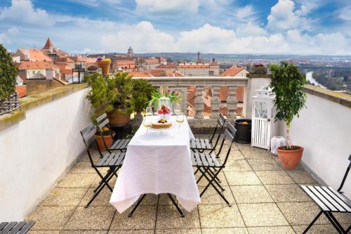 a table on a balcony with a view of a city at Boutique Apartments U Rolanda in Znojmo