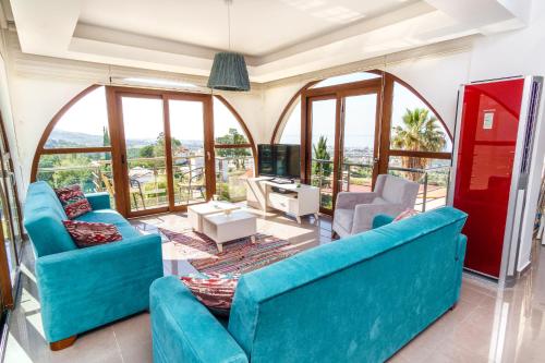 a living room with blue furniture and windows at Bellapais Apartments in Kérynia