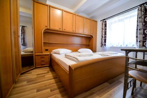a small bedroom with a bed with wooden cabinets at Vila Sabarel in Eforie Sud