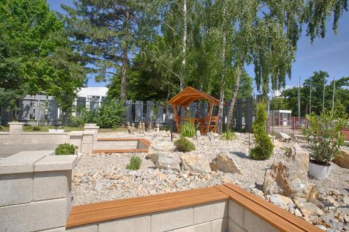 a garden with a bench and a gazebo at Agro Complex Apartments in Nitra