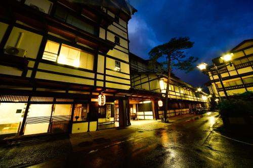 an empty city street at night with lit buildings at Osakaya Ryokan in Kusatsu