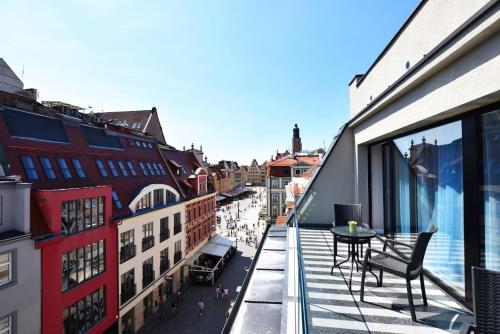 a balcony with a table and a view of a city at DUKES Apartments - Wita Stwosza in Wrocław