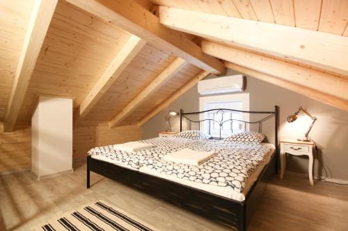 a bedroom with a black bed in a attic at Apartmány MALIK in Dolní Dunajovice