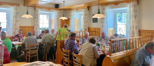 a group of people sitting at tables in a restaurant at Gasthof 'Zum alten Turm' in Haslach an der Mühl