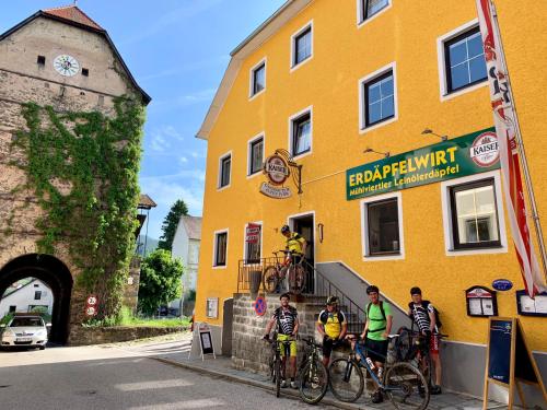 a group of people on bikes in front of a yellow building at Gasthof 'Zum alten Turm' in Haslach an der Mühl