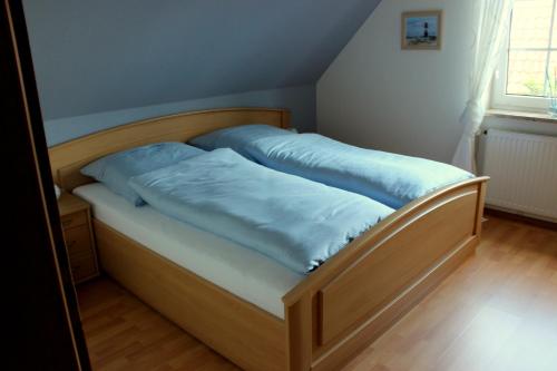 a bed with blue sheets on it in a room at Ferienwohnung Eggers in Bispingen
