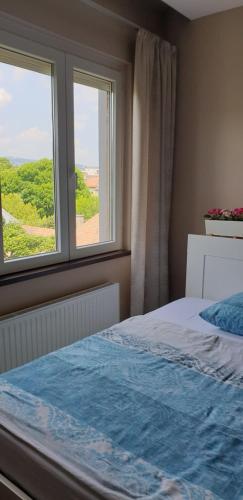 a bedroom with a bed and a window at Blue Ball Apartment in Budapest